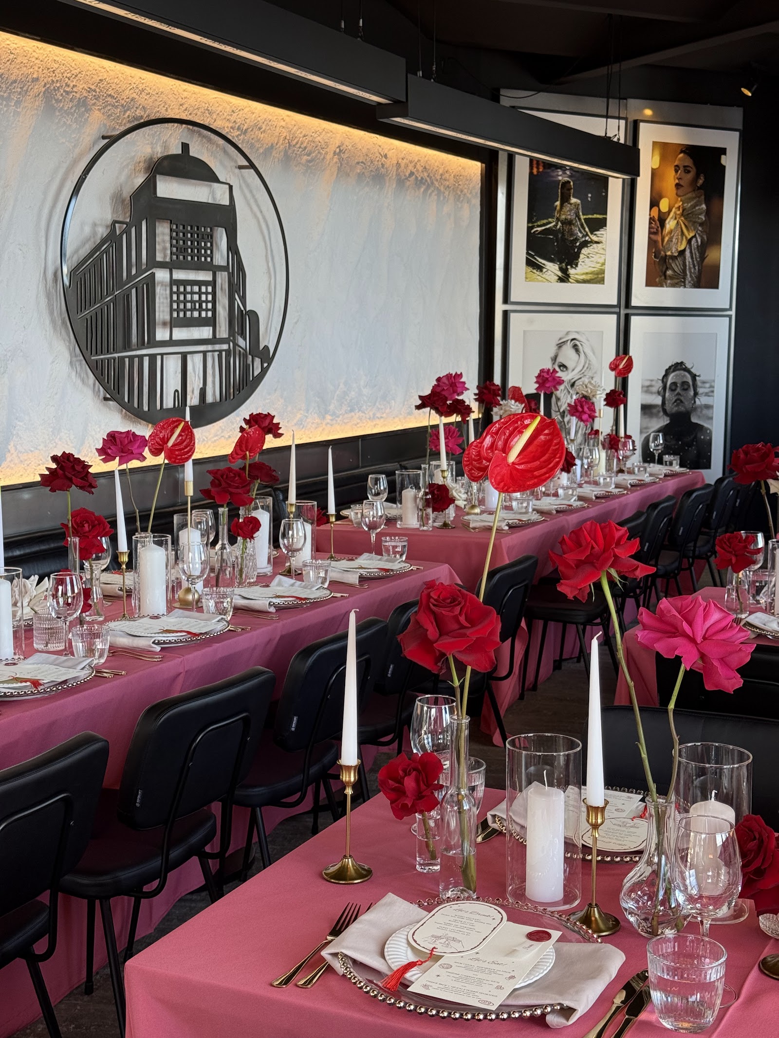 Long banquet table with red florals and candles — commercial dinner install