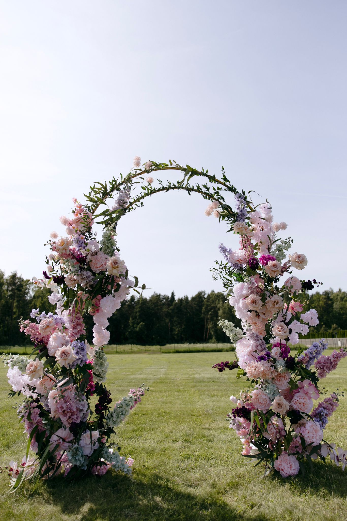 Pastel floral wedding arch — outdoor ceremony install